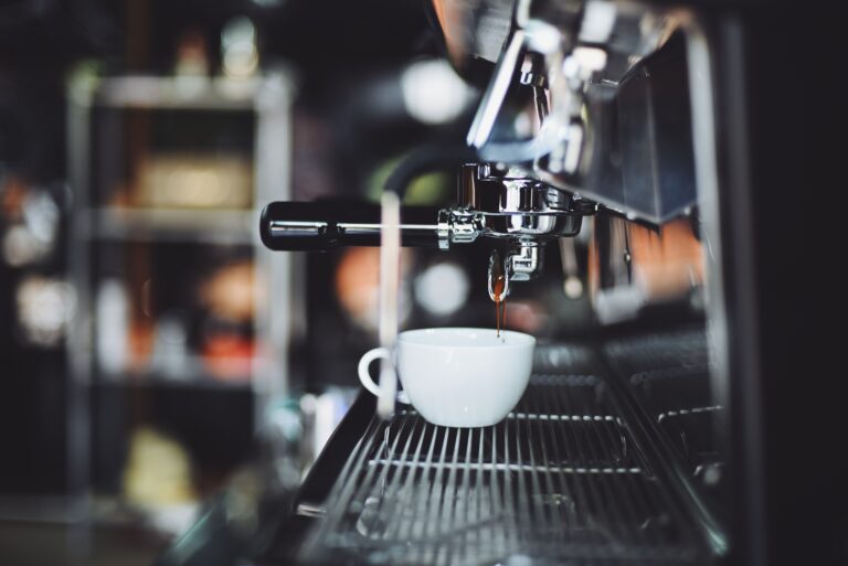 Espressomachine die koffie in een wit kopje schenkt
